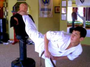 Instructor performing kick to dummy